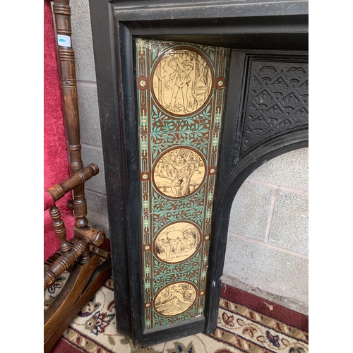 23 - A Victorian cast iron fire surround with ceramic tile inserts - approx. 100cm high x 102cm wide