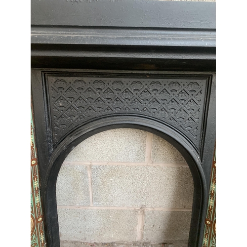 23 - A Victorian cast iron fire surround with ceramic tile inserts - approx. 100cm high x 102cm wide