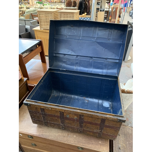 142 - Two early 20th century brown metal travel trunks