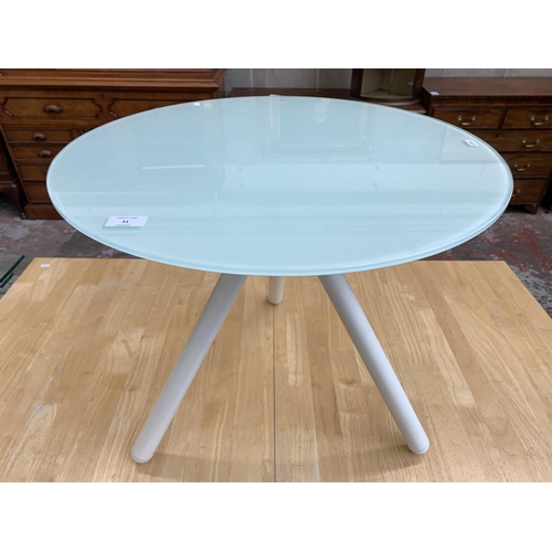 238 - A modern glass top and white metal tripod side table - approx. 50cm high x 60cm diameter