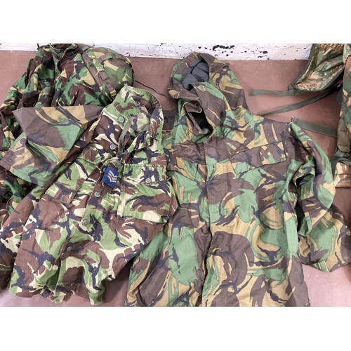 430 - A large quantity of camouflage military uniform and accessories to include Wynnster rucksack, helmet... 