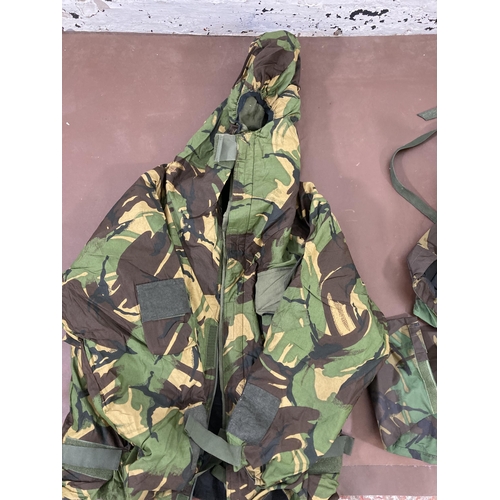 430 - A large quantity of camouflage military uniform and accessories to include Wynnster rucksack, helmet... 