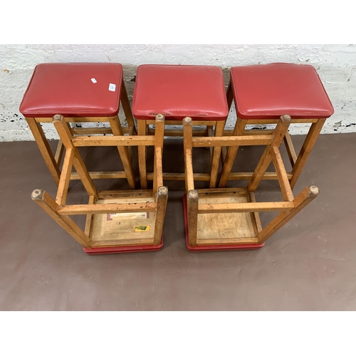 250A - Five mid 20th century beech and red vinyl upholstered stools - approx. 50cm high x 33cm wide x 28cm ... 