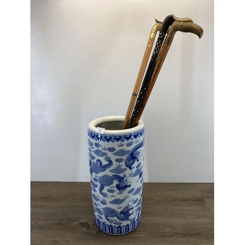 362 - A Chinese blue and white porcelain stick stand containing three novelty animal head top walking stic... 