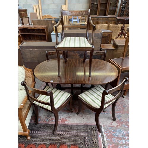 100 - A Georgian style mahogany twin pedestal extending dining table and five chairs