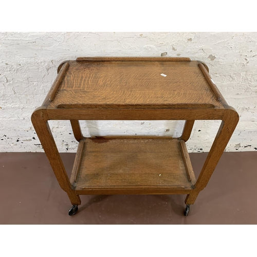 108 - An Art Deco style oak two tier tea trolley - approx. 79cm high x 38cm wide x 74cm deep