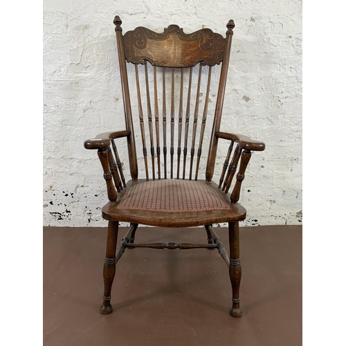 110 - A late 19th/early 20th century carved oak and fabric upholstered spindle back armchair - approx. 112... 