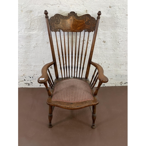 110 - A late 19th/early 20th century carved oak and fabric upholstered spindle back armchair - approx. 112... 