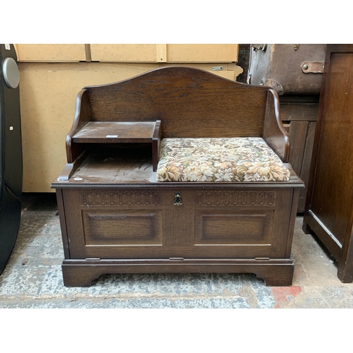 116 - An oak and tapestry upholstered telephone seat