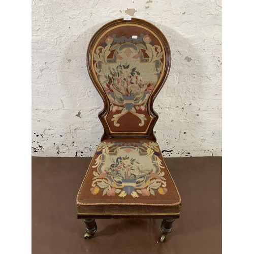 13 - A 19th century mahogany framed and tapestry upholstered nursing chair on brass castors stamped 