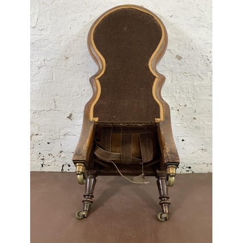 13 - A 19th century mahogany framed and tapestry upholstered nursing chair on brass castors stamped 