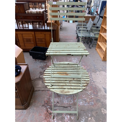 134 - A green painted metal folding two piece bistro set comprising circular table and chair