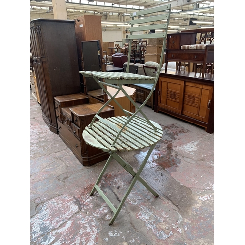 134 - A green painted metal folding two piece bistro set comprising circular table and chair