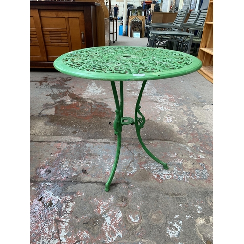 136 - A Victorian style green painted cast metal three piece patio set - table approx. 62cm high x 66cm di... 