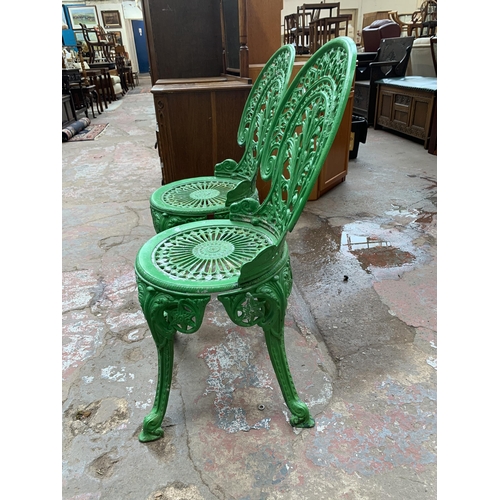 136 - A Victorian style green painted cast metal three piece patio set - table approx. 62cm high x 66cm di... 