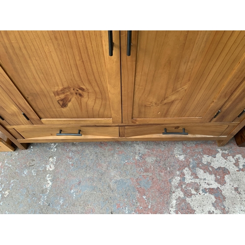 145 - A modern pine two door TV cabinet - approx. 127cm high x 120cm wide x 69cm deep