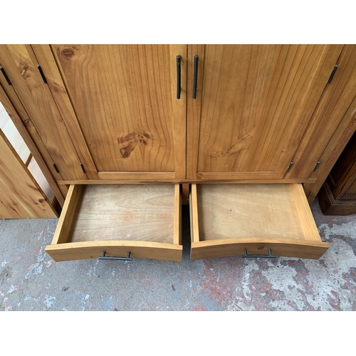 145 - A modern pine two door TV cabinet - approx. 127cm high x 120cm wide x 69cm deep