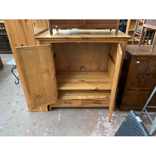 145 - A modern pine two door TV cabinet - approx. 127cm high x 120cm wide x 69cm deep