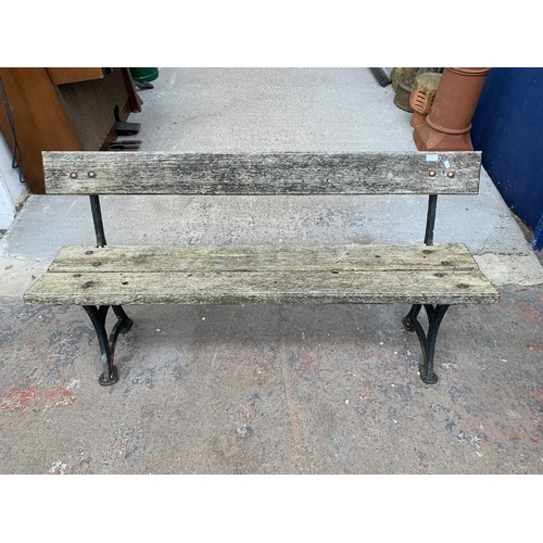 150 - A late 19th/early 20th century Needham Stockport cast iron and wooden slatted garden bench - approx.... 