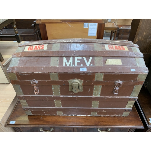 157 - An early 20th century brown painted fibreboard dome top travel trunk with wooden and brass banding -... 