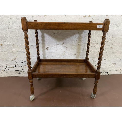 169 - A mid 20th century oak barley twist two tier tea trolley - approx. 70cm high x 38cm wide x 61cm long