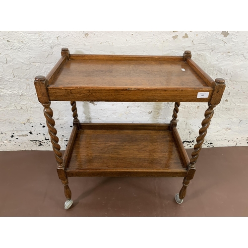 169 - A mid 20th century oak barley twist two tier tea trolley - approx. 70cm high x 38cm wide x 61cm long