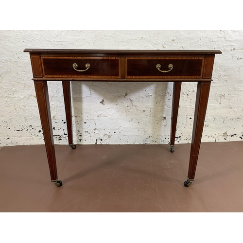 170 - An Edwardian inlaid mahogany two drawer writing table with black leather insert and tapering support... 