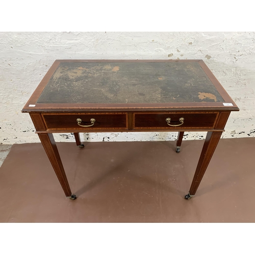 170 - An Edwardian inlaid mahogany two drawer writing table with black leather insert and tapering support... 