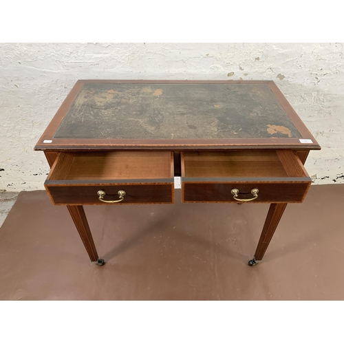 170 - An Edwardian inlaid mahogany two drawer writing table with black leather insert and tapering support... 