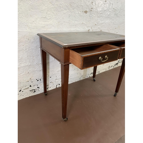 170 - An Edwardian inlaid mahogany two drawer writing table with black leather insert and tapering support... 