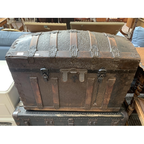 178 - An early 20th century embossed metal coated and wooden banded dome top travel trunk - approx. 57cm h... 