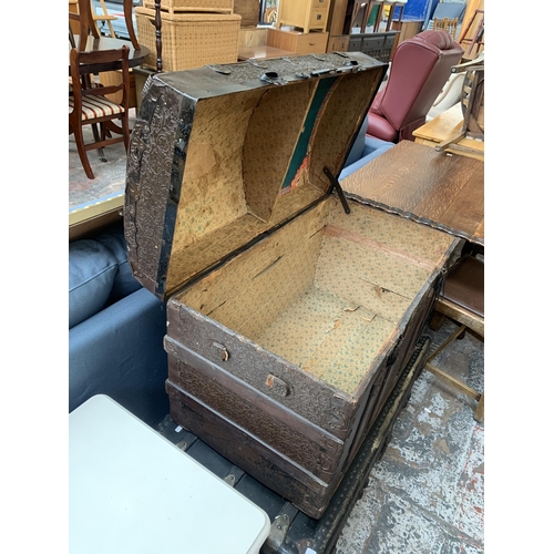 178 - An early 20th century embossed metal coated and wooden banded dome top travel trunk - approx. 57cm h... 