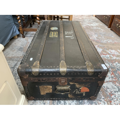 179 - An early 20th century black painted fibreboard travel trunk - approx. 35cm high x 100cm wide x 53cm ... 