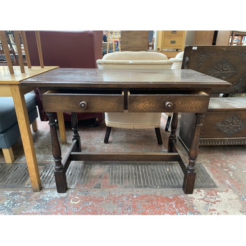 184 - An early/mid 20th century oak two drawer console table - approx. 76cm high x 107cm wide x 60cm deep