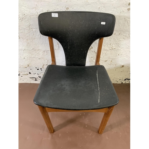 20 - Four mid 20th century teak and black vinyl upholstered dining chairs