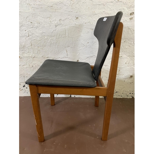 20 - Four mid 20th century teak and black vinyl upholstered dining chairs