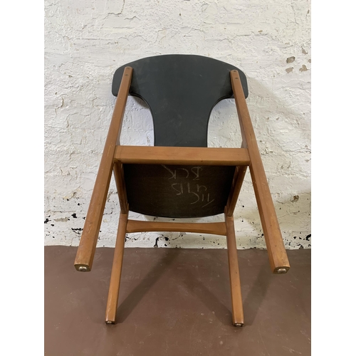 20 - Four mid 20th century teak and black vinyl upholstered dining chairs