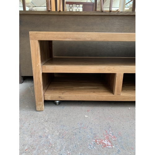 225 - A modern solid oak TV stand with removable storage compartment on castors - approx. 54cm high x 180c... 