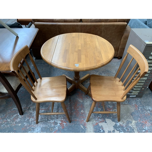 239 - A modern beech circular drop leaf dining table and two chairs - approx. 75cm high x 91cm diameter