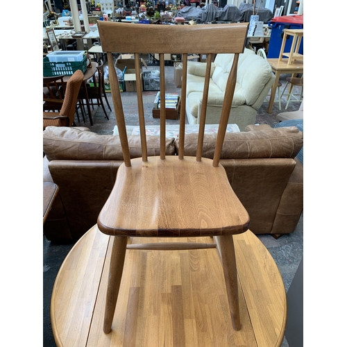 239 - A modern beech circular drop leaf dining table and two chairs - approx. 75cm high x 91cm diameter