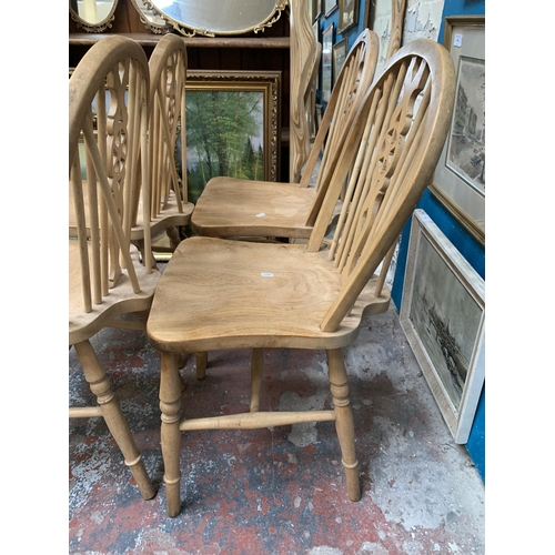 27 - Four elm and beech wheelback dining chairs