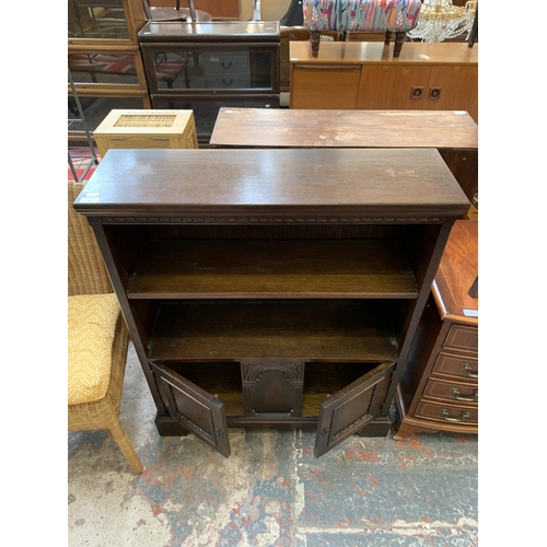 30 - A carved oak two tier bookcase - approx. 102cm high x 84cm wide x 25cm deep