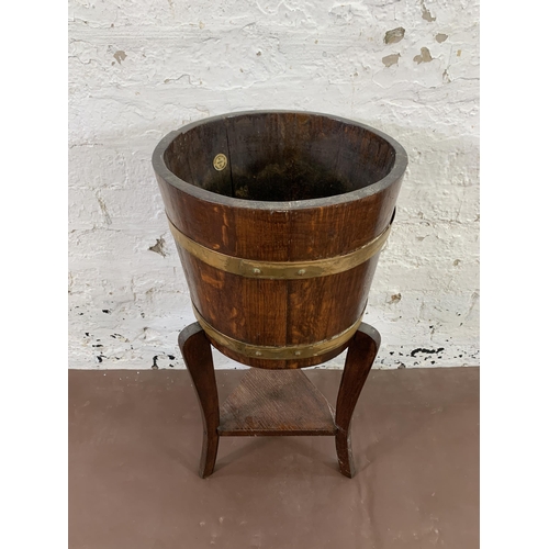 31 - An early 20th century R.A. Lister & Co. Ltd. oak and brass banded barrel shaped planter - approx. 68... 