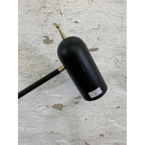 33 - A modern black metal and brass LED floor lamp - approx. 130cm high