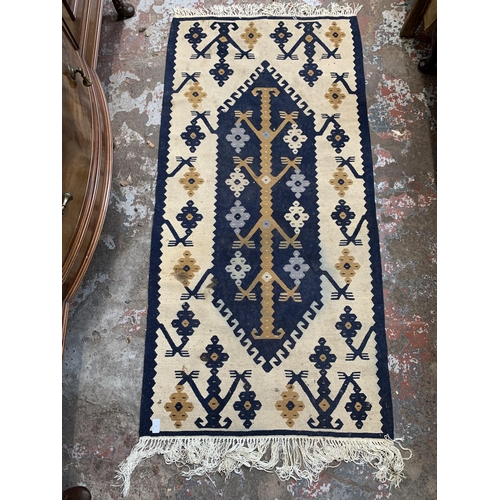 4 - A blue and cream Kilim rug - approx. 155cm x 75cm