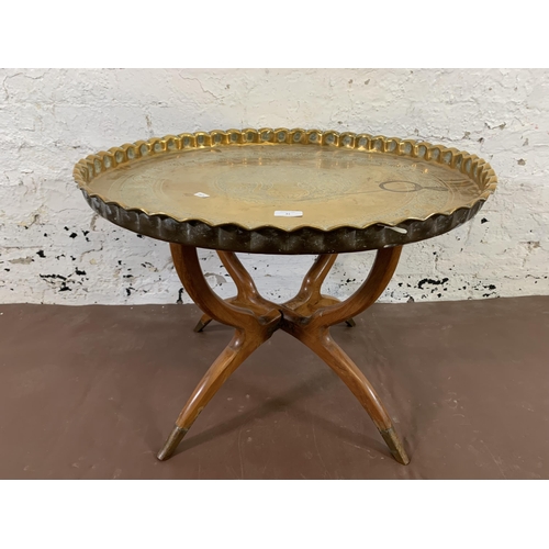 41 - A mid 20th century hardwood folding spider leg travel table with engraved brass circular tray - appr... 