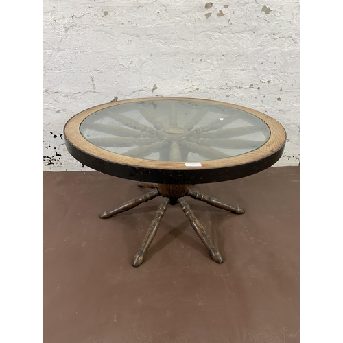 42 - A mid 20th century oak and glass top revolving ships wheel coffee table - approx. 42cm high x 74cm w... 