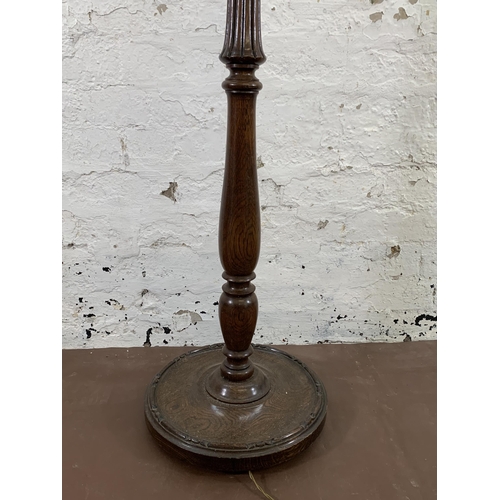 44 - An early/mid 20th century oak reeded standard lamp with circular base - approx. 154cm high (excludin... 