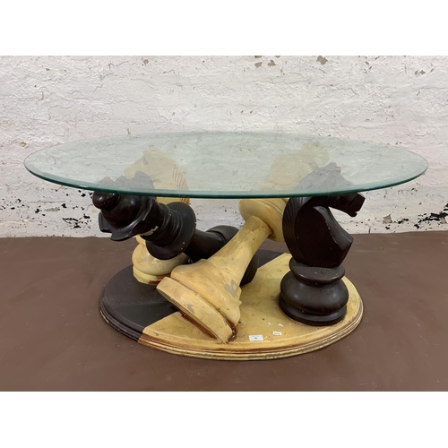 68 - A modern painted fibreglass and bevelled glass top chess piece coffee table - approx. 50cm high x 80... 