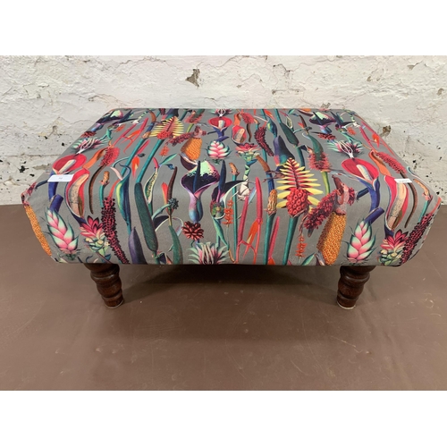 72 - A modern floral fabric upholstered footstool with turned wooden supports - approx. 33cm high 65cm wi... 